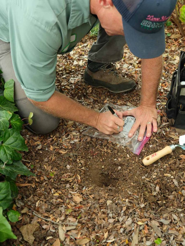 man labeling soil sample bag for lab testing
