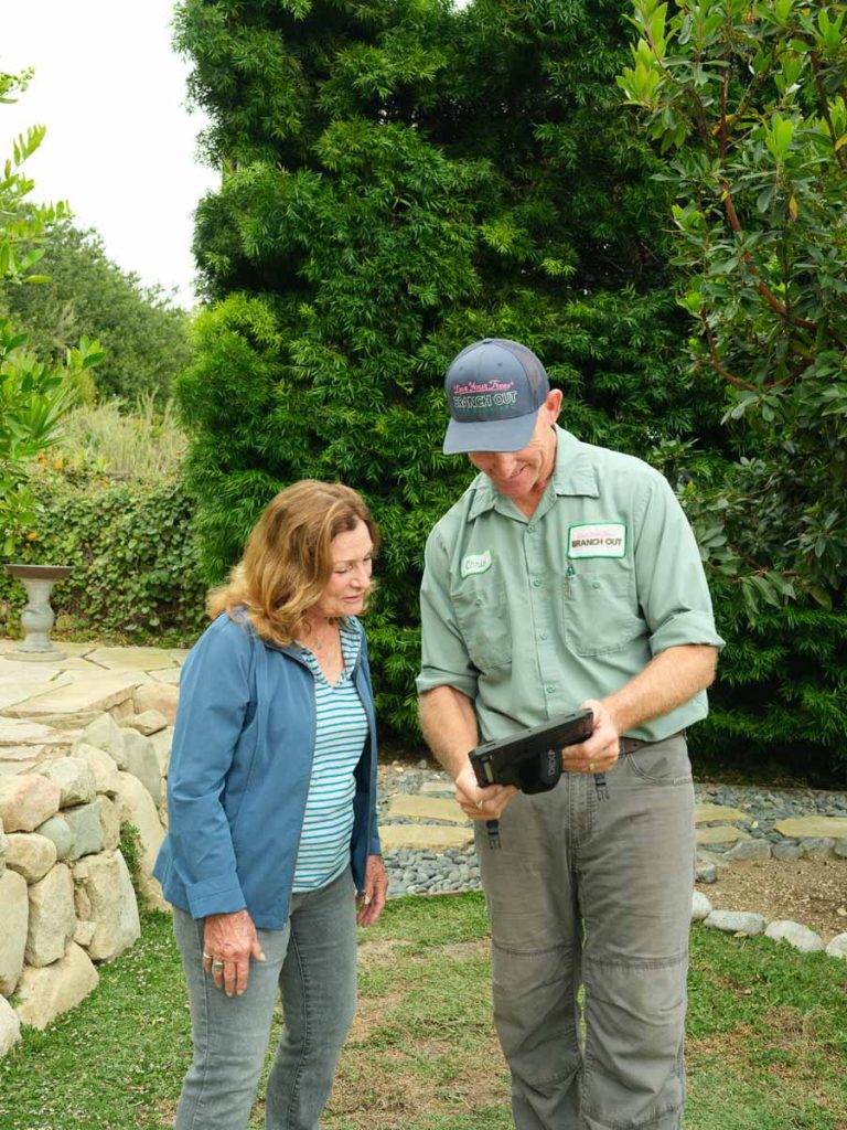 woman and arborist reviewing a tablet